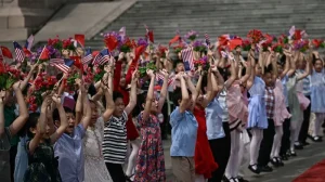 children waving small American flags and holding flowers in honour of Presidents Trump 