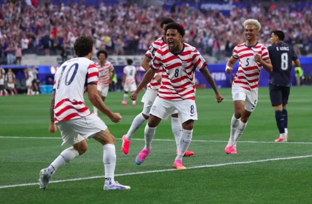 USA's Christian Pulisic celebrates own goal scored by Paraguay with teammates.